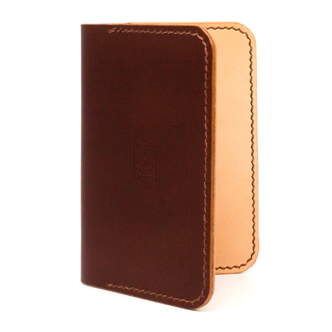 Outside of brown folding cardholder showing stitching and contrasting nude inside.